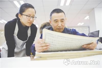 刘建明正在指导徒弟装帧古籍。